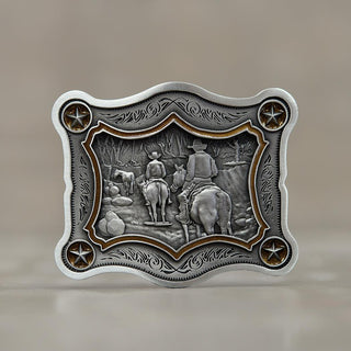 Artistic pewter belt buckle featuring two cowboys riding horses in a scenic landscape