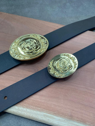 Elegant rose design belt buckle in gold finish on a black leather belt
